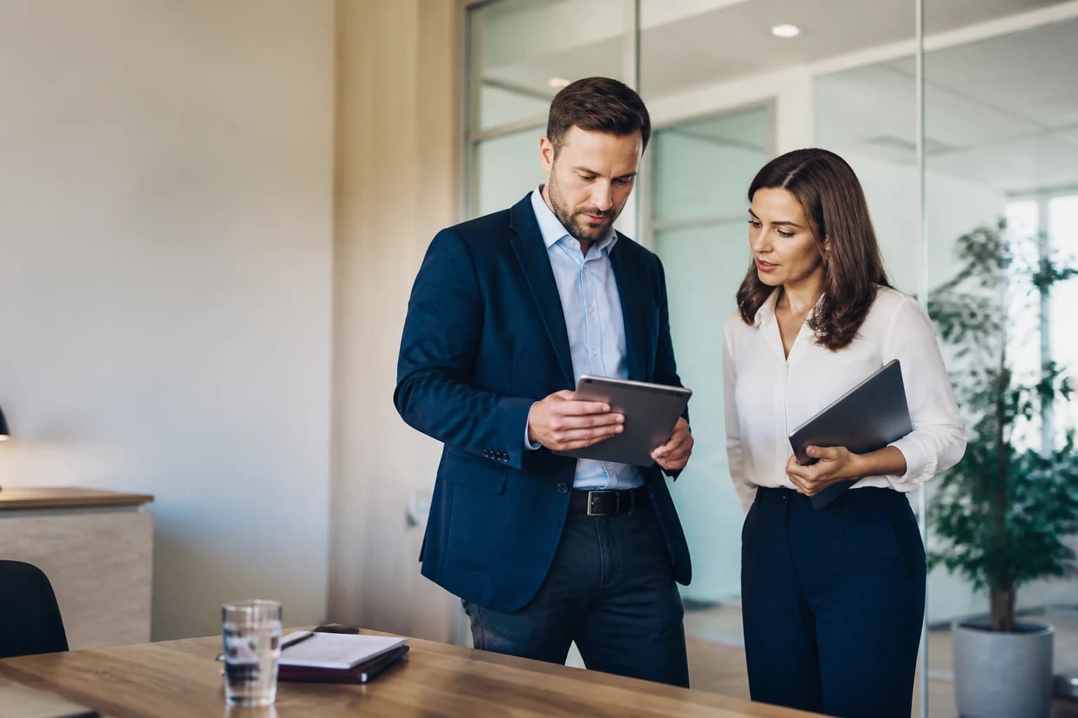 Two financial advice professionals reviewing work together in an office